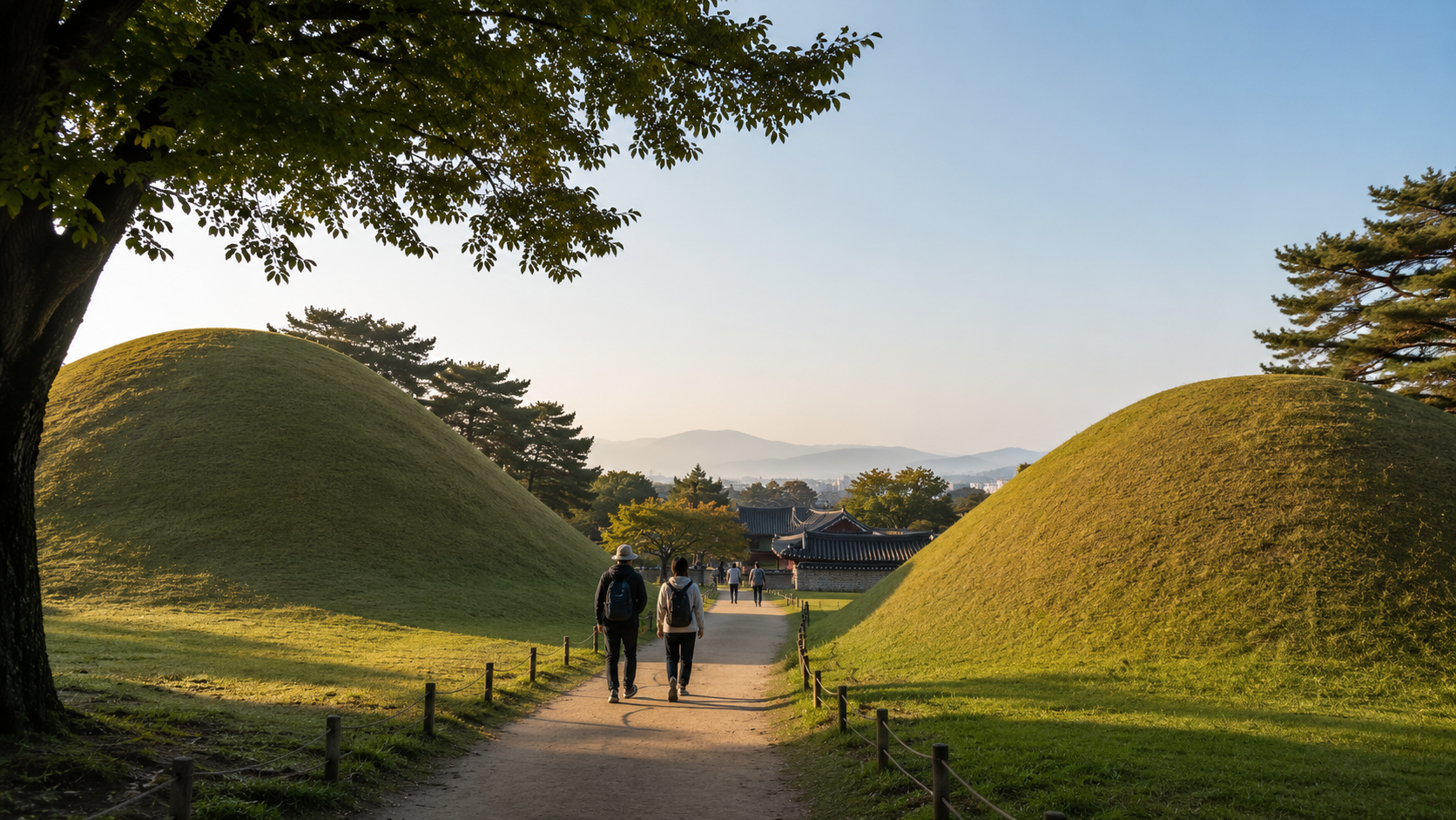 Visitors walking between royal burial mounds in central Gyeongju during early morning