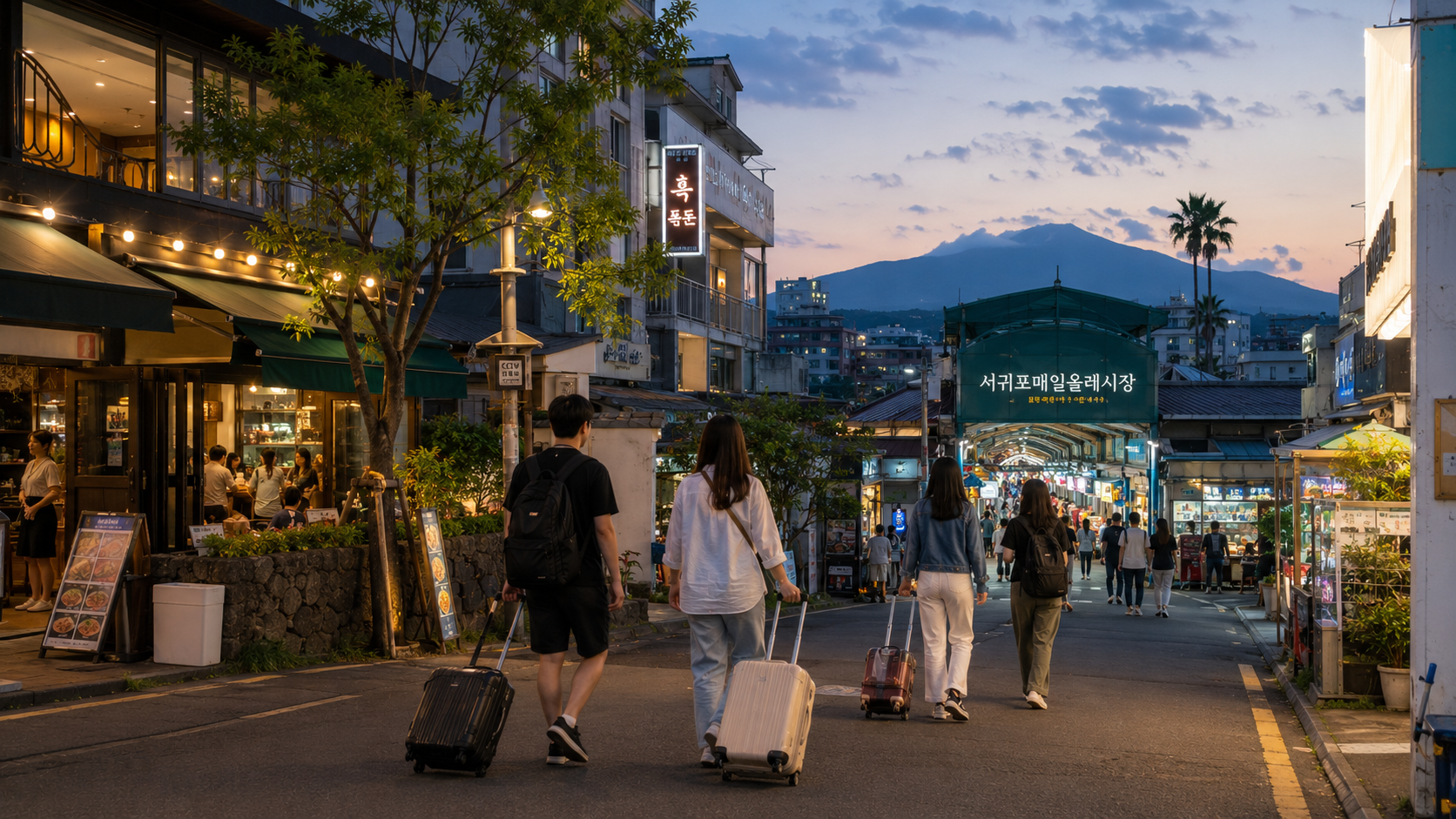 Travelers walking with small suitcases near Seogwipo Maeil Olle Market in the early evening
