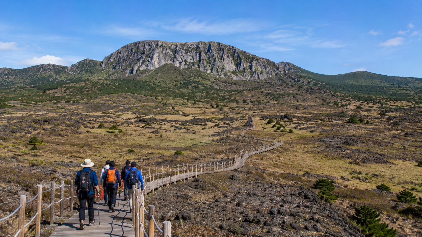 Hikers crossing the open volcanic landscape near Witse Oreum on Hallasan